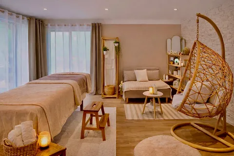 L'institut BabyMum Relax à Ozoir-la-Ferrière : table de massage, coin salon et fauteuil suspendu en rotin dans une lumière douce