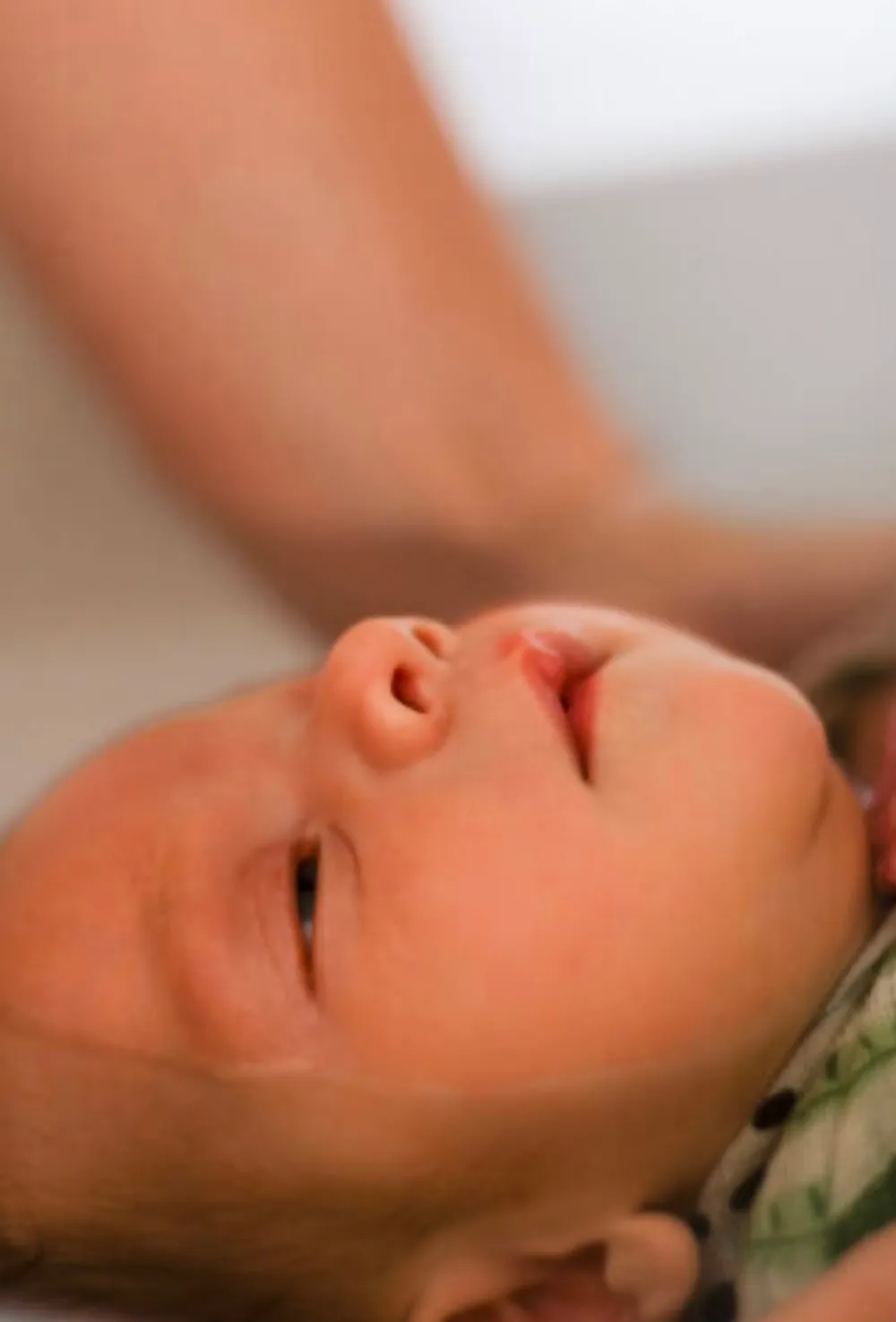 Gros plan sur le visage endormi d'un nouveau-né pendant le bain enveloppé