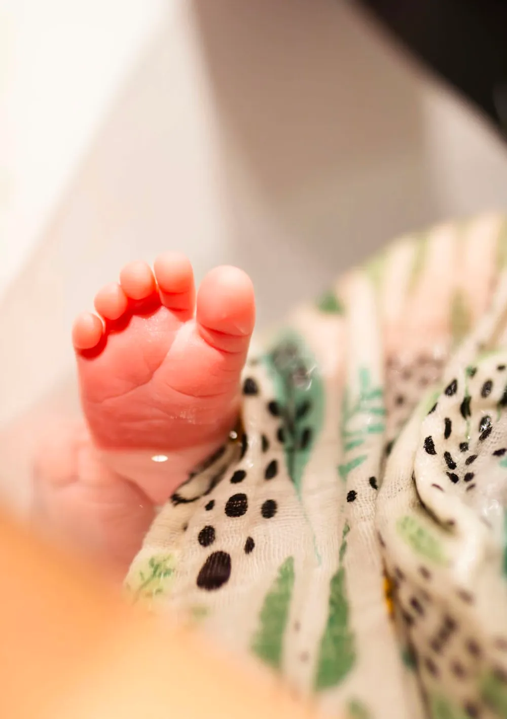 Gros plan sur les pieds d'un nouveau-né pendant son bain enveloppé